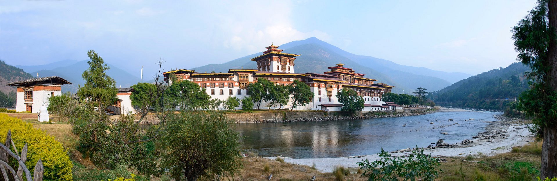 Amankora Punakha Lodge nestled in a serene Himalayan valley surrounded by lush greenery and traditional Bhutanese architecture.